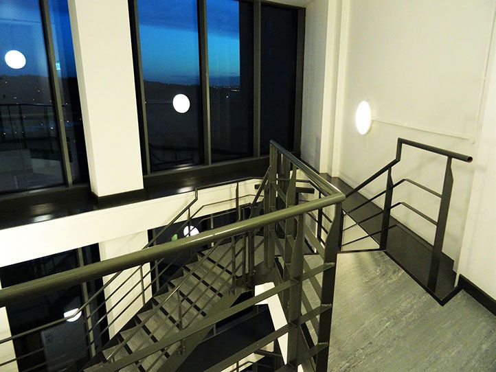 A photo of metal stairs inside a building with the lights on