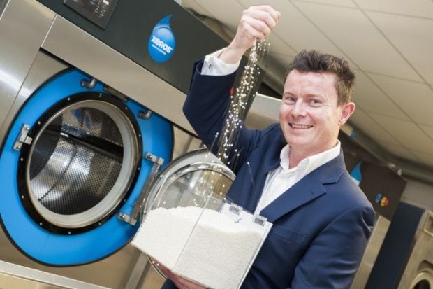 A photo of a man pouring white balls into a container of white balls