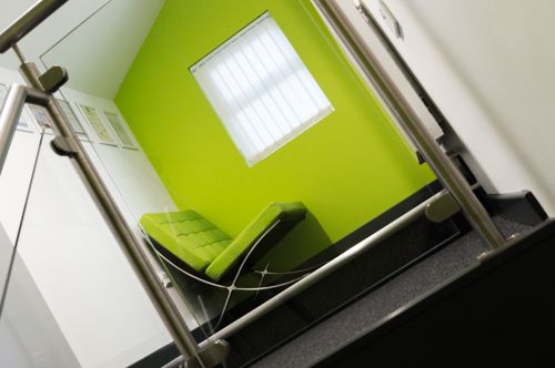 A photo of a chill out area with a green wall and green sofa