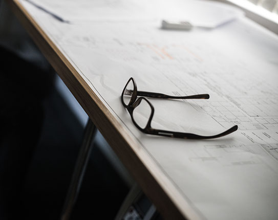 A pair of glases resting on blueprints